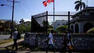 Image: People pass by the Canada's Embassy in Havana