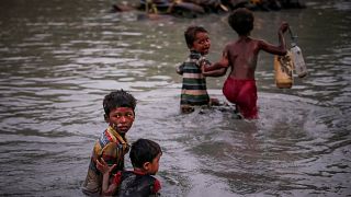 Image: Rohingya siblings fleeing violence hold one another as they cross th