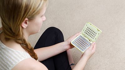 Teen girl holding birth control pills Teen girl holding birth control pills