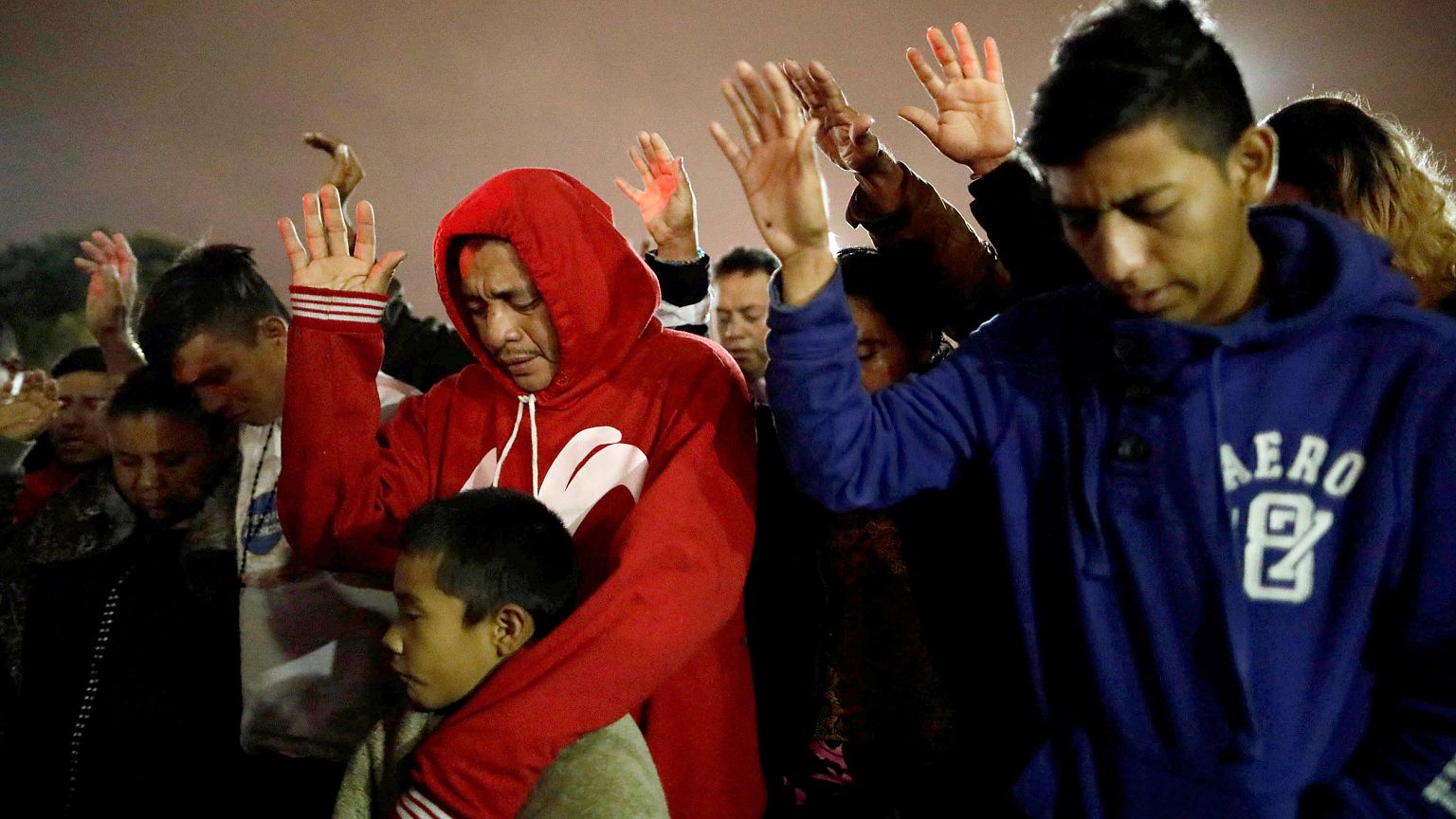 Image: Members of a caravan of migrants from Central America, pray near the