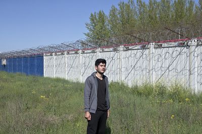 Rohollah Mohammadi waits on the Serbian side of the border fence.