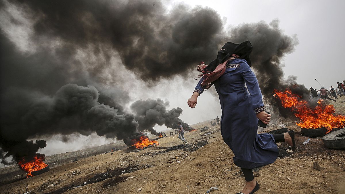 Image: A female Palestinian protester throws stones during clashes 
