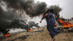 Image: A female Palestinian protester throws stones during clashes 