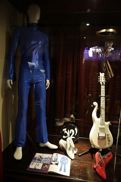 Prince\'s Schecter White Cloud electric guitar, a custom electric-blue ensemble from a 1999 performance at Paisley Park with Lenny Kravitz, and two pairs of booties.