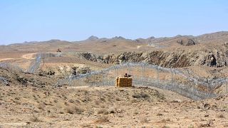 Image: A Pakistani army soldier stands guard along with border fence with A