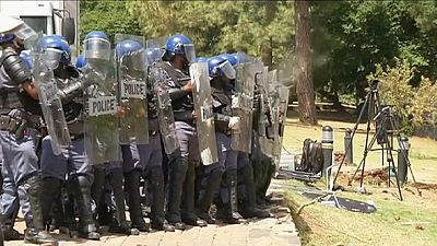 South African students break down a fence around government buildings