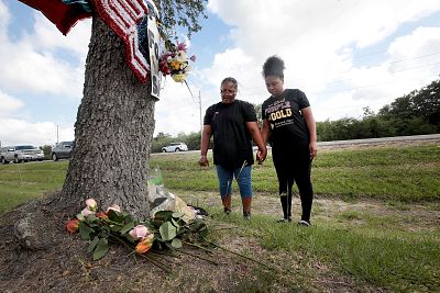Ulrica Fontenot and her daughter Takeisa pray after leaving flowers at a small memorial outside of Santa Fe High School on May 19, 2018 in Santa Fe, Texas.