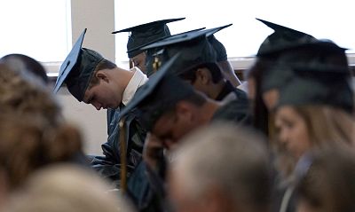 Santa Fe High School graduates bow their heads in prayer during a baccalaureate service Sunday in Santa Fe, Texas.