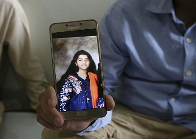 Abdul Aziz Sheikh, the father of Sabika Sheikh, a victim of a shooting at a Texas high school, shows a picture of his daughter Saturday in Karachi, Pakistan.
