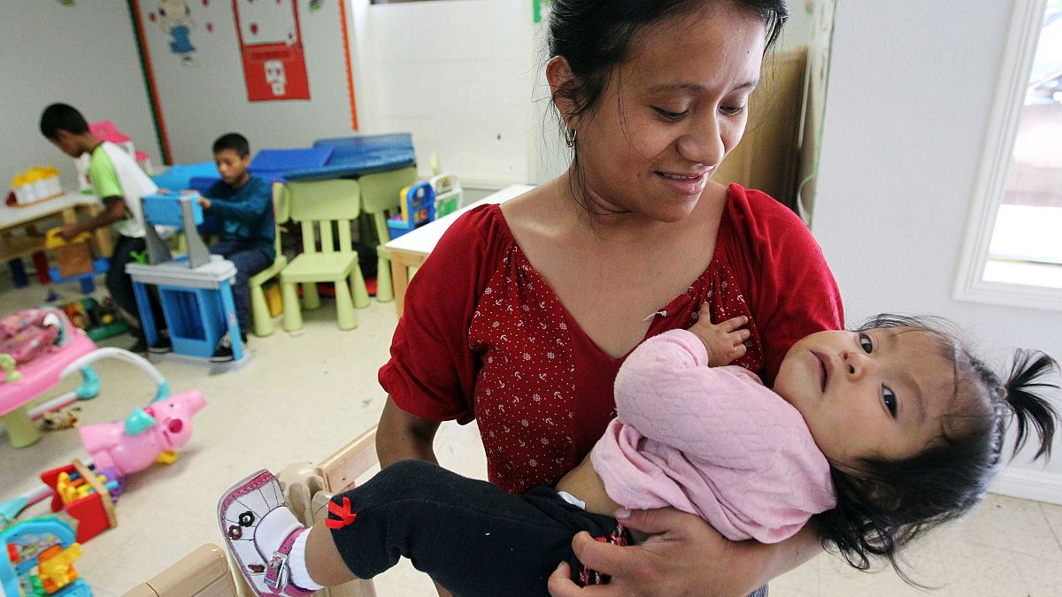 Image: A mother holder her daughter at a shelter