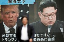 Image: A pedestrian walks in front of a screen in Tokyo showing Donald Trum