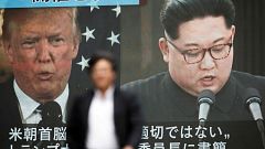 Image: A pedestrian walks in front of a screen in Tokyo showing Donald Trum