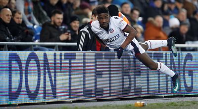 Sammy Ameobi, who plays for the Bolton Wanderers, climbs over an advertisement warning against the pitfalls of betting during a soccer game at Cardiff City Stadium on Feb. 13.