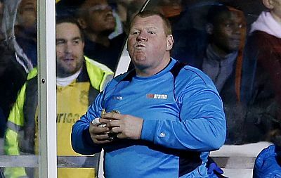Sutton United player Wayne Shaw eats a pie during a match against Arsenal on Feb. 20, 2017.