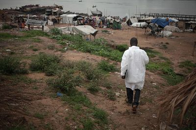 A health worker from the Ministry of Health walks as he waits to monitor the temperature of travellers from the Democratic Republic of Congo in a port of Bangui on June 3, 2018.
