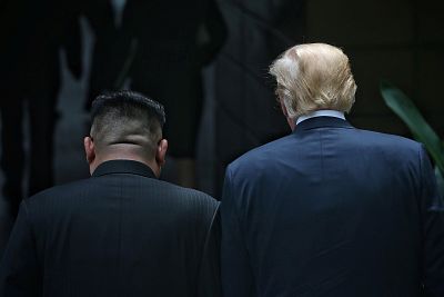 Donald Trump walks with Kim Jong Un on Tuesday.