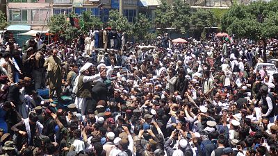 A group congregates around alleged Taliban militants in Paktia, Afghanistan, on Saturday.