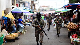Image: Salvadoran soldiers patrol in downtown San Salvador after six market