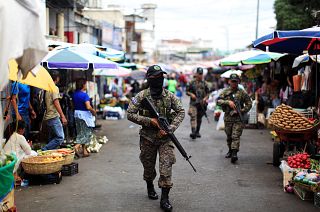Image: Salvadoran soldiers patrol in downtown San Salvador after six market