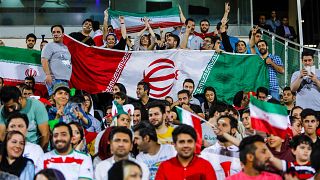 Image: People wave flags in Azadi stadium in Tehran