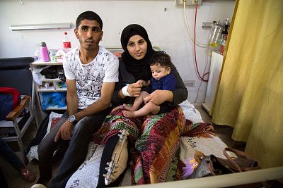 Asma Abu Daqa with her husband, Mohammed, and her baby son, Amir, while being treated in hospital.