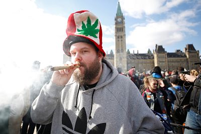 A man smokes marijuana during the annual 4/20 marijuana rally on Parliament Hill in Ottawa, Ontario, Canada on April 20, 2018.