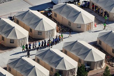 Immigrant children housed in a tent encampment under the new "zero tolerance" policy by the Trump administration walk in single file at the facility near the Mexican border in Tornillo, Texas on June 19, 2018.