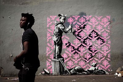 The \'Banksy\' of a girl spraypainting over a swastika, shown here before the work itself was vandalized.
