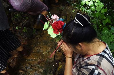 A woman prays near the Tham Luang cave.