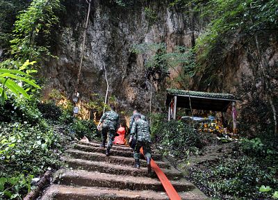 Military personnel enter a cave amid rescue efforts for the missing soccer players players and their coach.