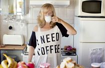 Caucasian woman drinking coffee in kitchen