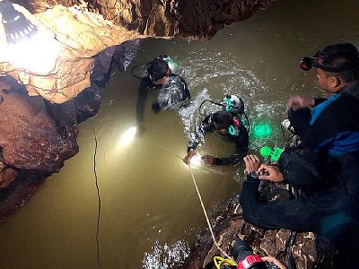 A team of Thai divers inspects a water-filled tunnel.