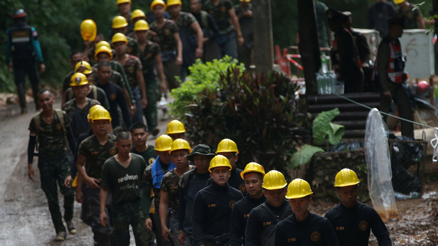 Image: Military personnel walk in line as they prepare to enter the Tham Lu