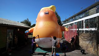 Image: People inflate a helium filled Donald Trump blimp which they hope to