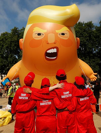 Demonstrators watch the Trump blimp being inflated Friday morning.