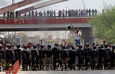 Iraqi police prevent protesters storming a provincial council building in Basra, Sunday.