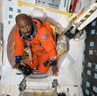 Astronaut Leland Melvin, STS-129 mission specialist, attired in a training version of his shuttle launch and entry suit, participates in a Full Fuselage Trainer (FFT) mock-up training session in the Space Vehicle Mock-up Facility at NASA\'s Johnson Space Center.