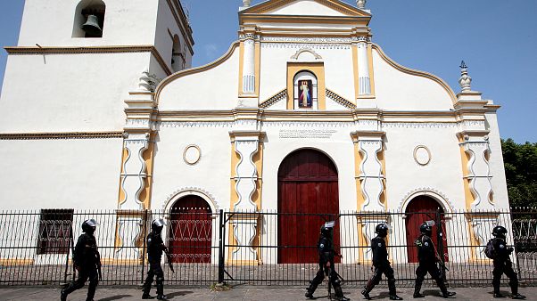 Image: Members of Nicaragua's Special Forces walk past a church during clas Image: Members of Nicaragua's Special Forces walk past a church during clas