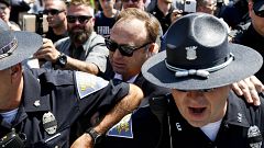 Image: Alex Jones, center, is escorted out of a crowd of protester