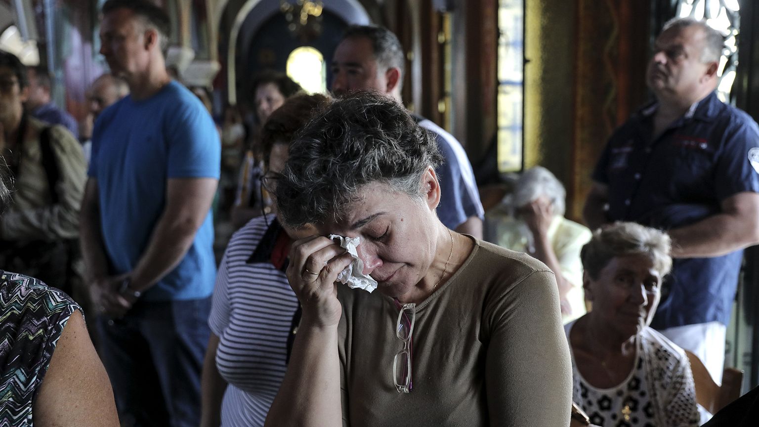 Image: Worshipers attend a memorial service for the victims of a forest fir