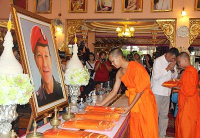 Members of theWild Boar soccer team put saffron robes in front of a portrait of former Thai Navy Seal Petty Officer 1st class Saman Kunan, who died in the Tham Luang cave rescue operations.