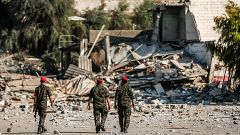 Image: Members of Hamas' military police walk through a site that was hit b