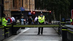 Image: Police officers stand at the vehicle barrier to the Houses of Parlia