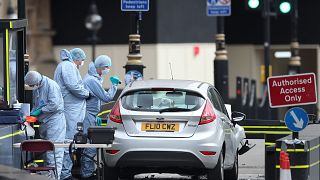 Image: Police forensics officers work around a silver Ford Fiesta car that 