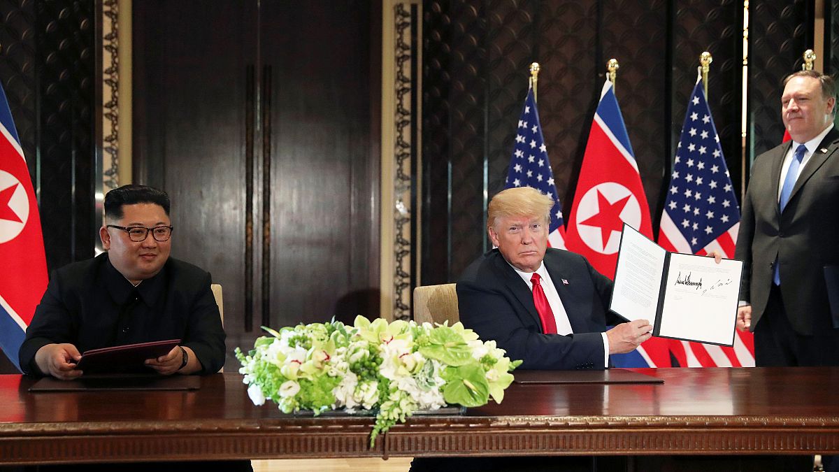U.S. President Donald Trump shows the document, that he and North Korea's l