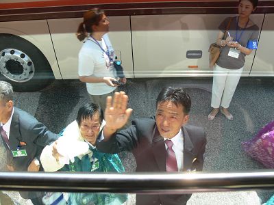 Chung Hak-soon\'s sister-in-law and nephew wave goodbye to her outside the bus that will take her back to South Korea. It is unlikely she will be permitted to meet them again.
