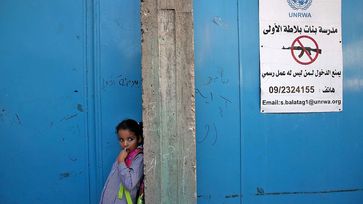 Image: A girl stands at the entrance of a school run UNRWA in the West Bank