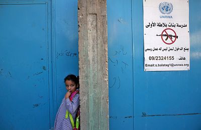 A girl stands at the entrance of a school run by UNRWA in the West Bank on Wednesday, which was the first day of classes after the summer holidays.