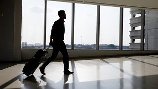 Image: A traveler passes through Philadelphia International Airport Thursda