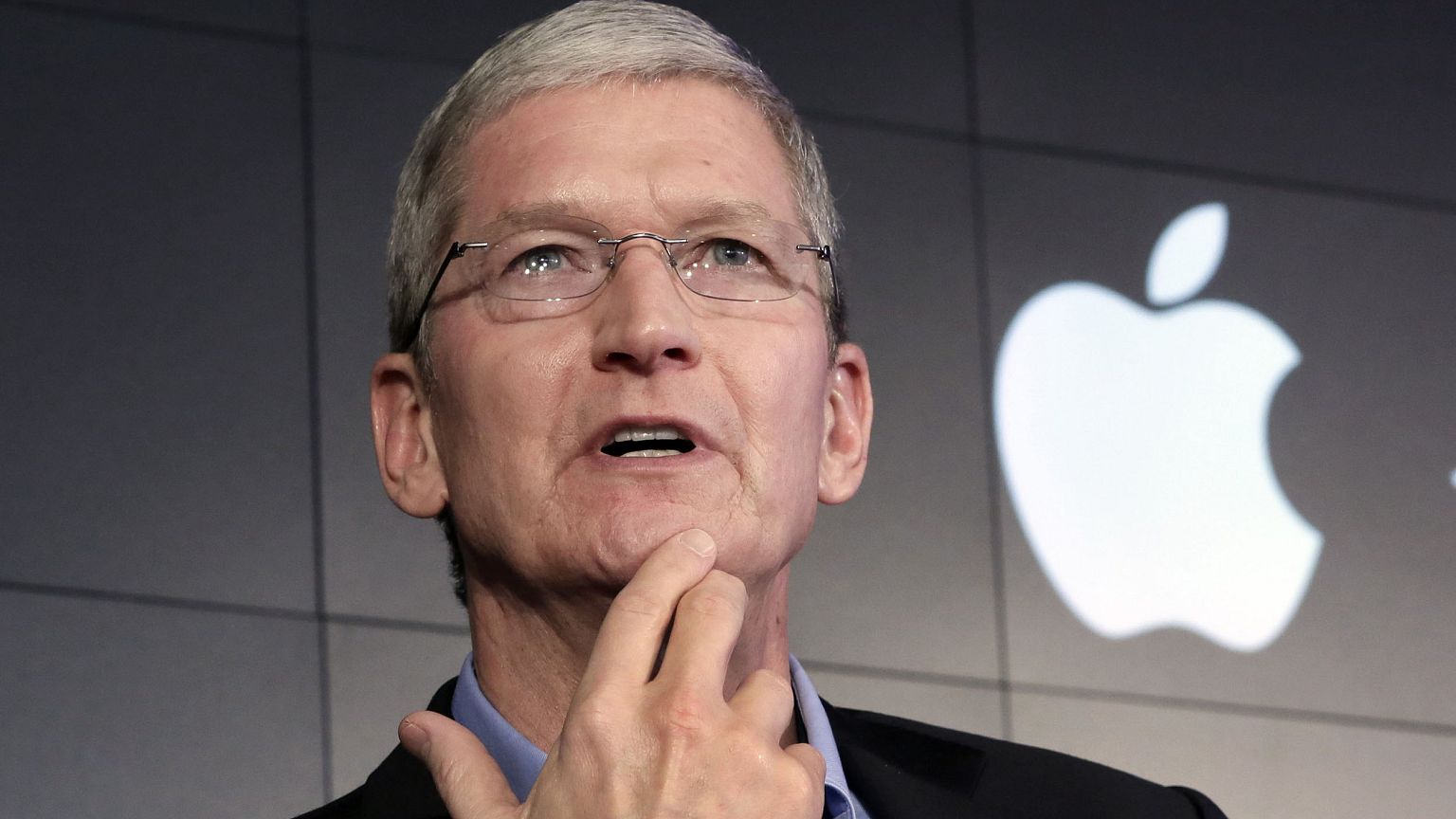 Image: Apple CEO Tim Cook responds to a question during a news conference